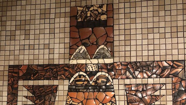 Earth-toned tile mosaic in the shape of a (loosely) Native American kachina figure
