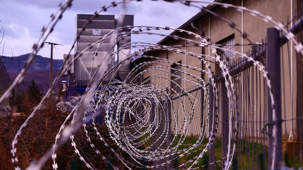 A spiraling coil of concertina wire outside a prison