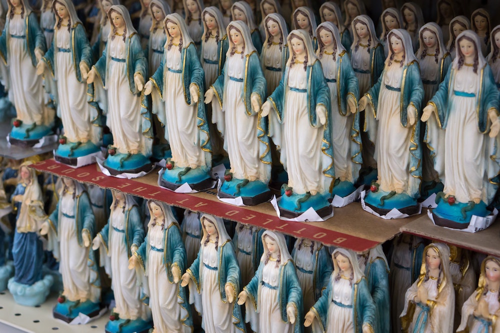 Small statues of a European-style Virgin Mary lining store shelves