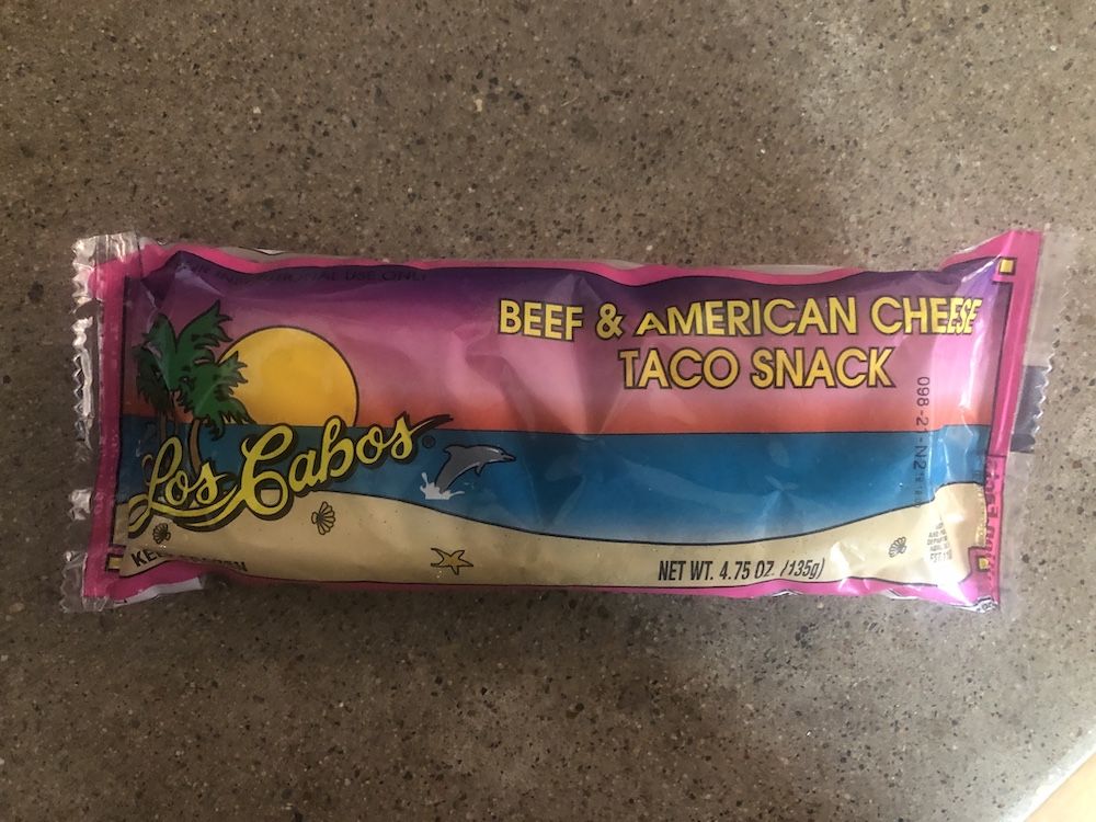 Packaged burrito labeled "Beef & American Cheese Taco Snack"