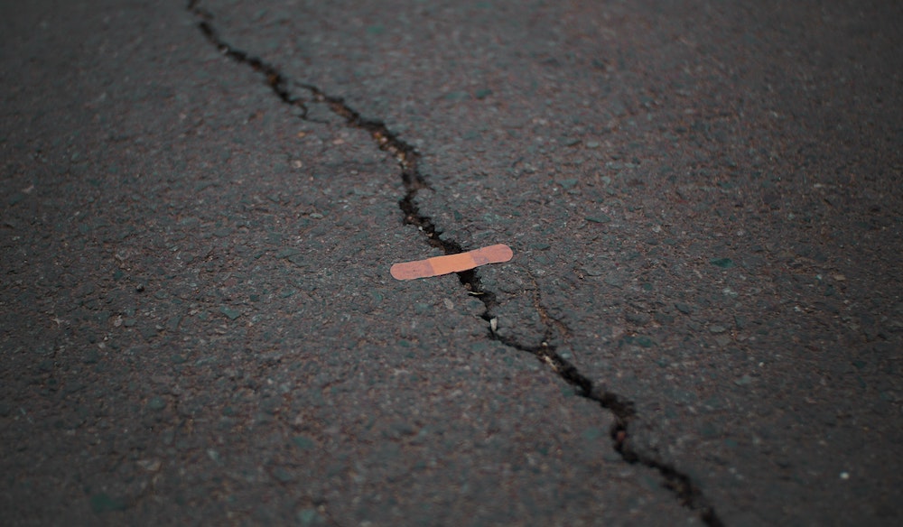 Cracked pavement "held together" by a band-aid