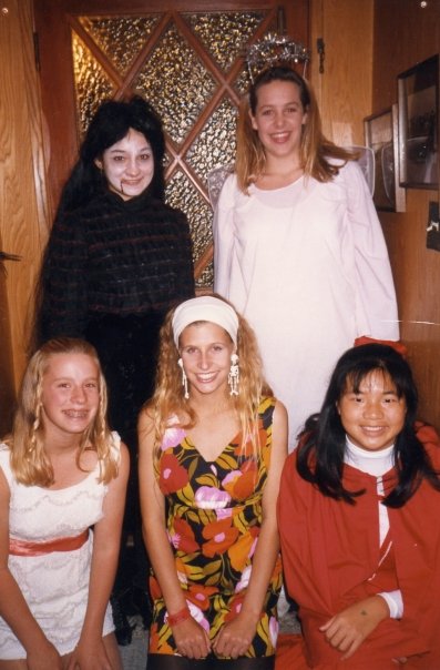 Five high school girls in Halloween costumes: a vampire, angel, Marcia Brady, go-go dancer, and Red Riding Hood