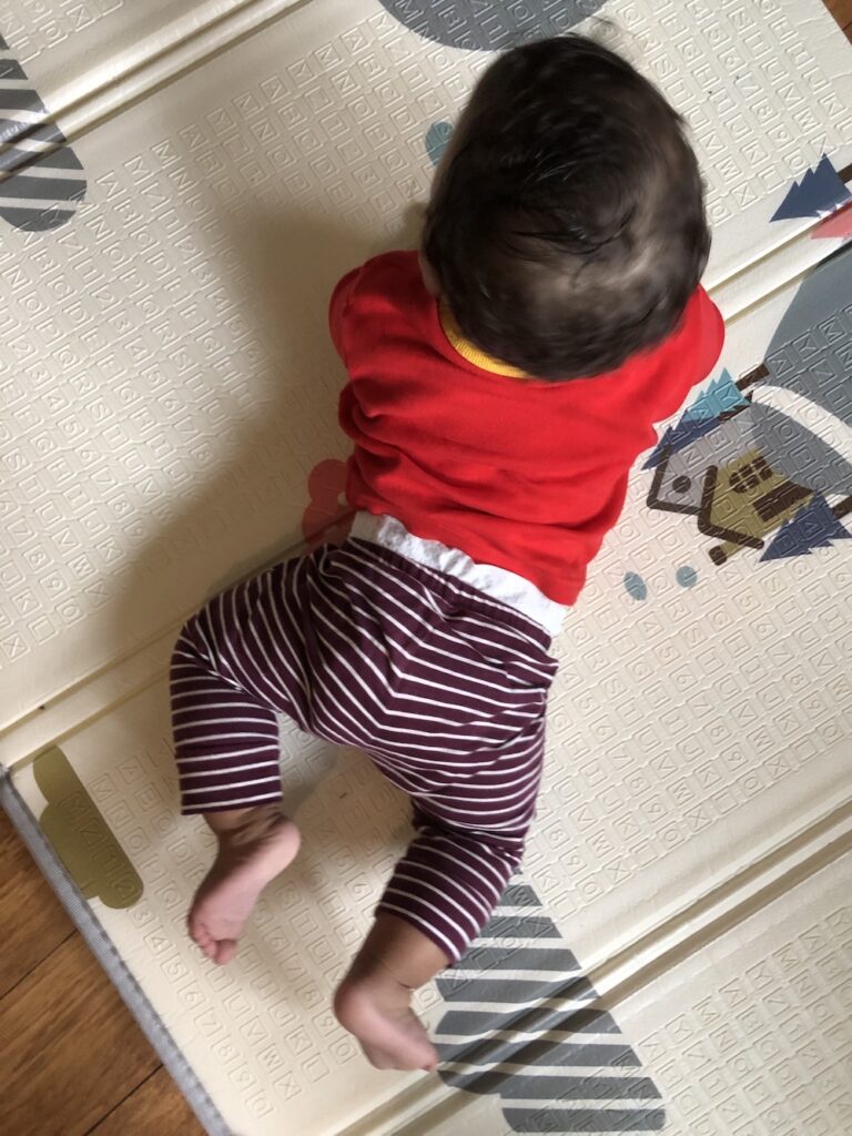 A baby on his hands and knees, viewed from above