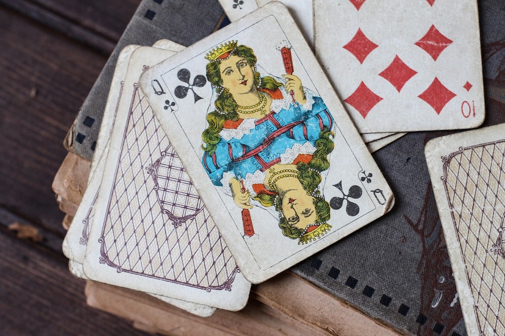 Vintage playing cards. The queen of spades and 10 of diamonds are face-up.