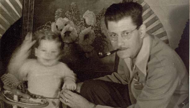 1940s photo of a toddler and his father, who has glasses and a pipe