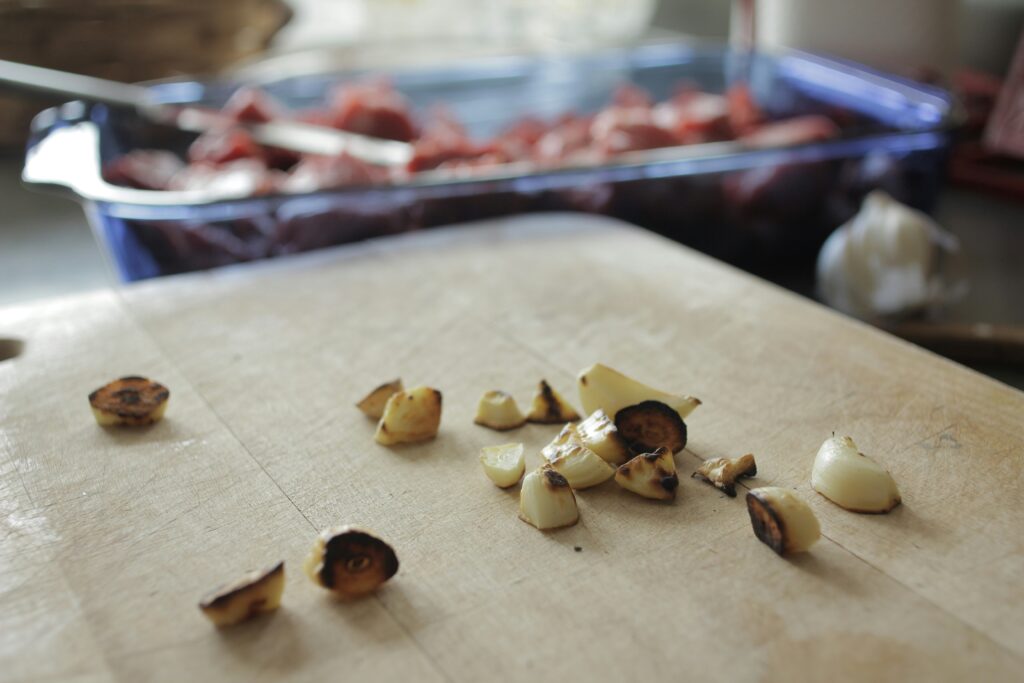 Chopped, partially burnt garlic on a cutting board