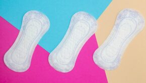 Three menstrual pads against a multicolored background