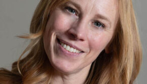 Close-up of a smiling woman with light skin and blonde hair