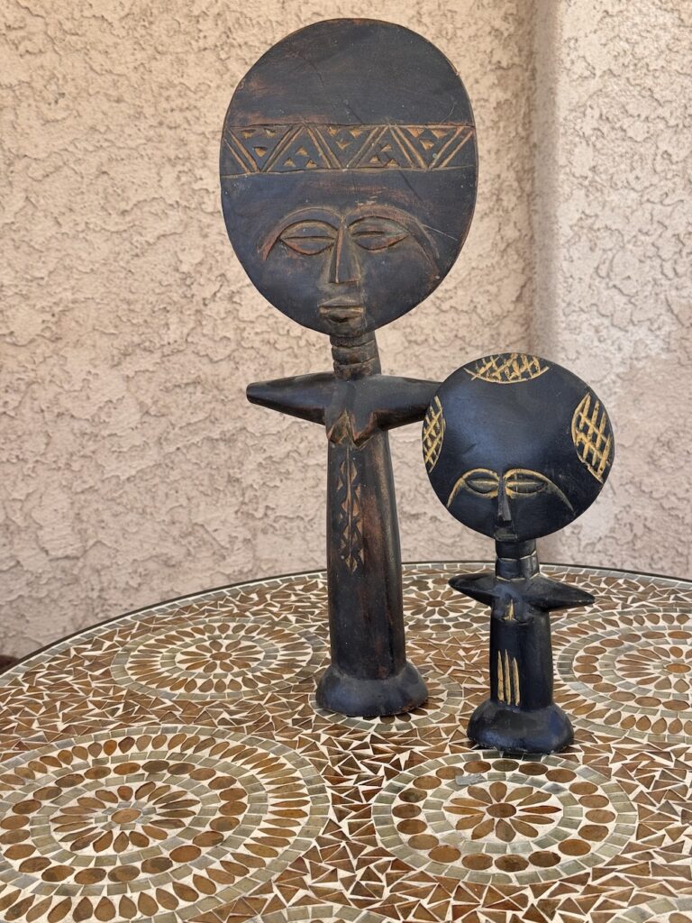 Wooden fertility dolls from Ghana with big round heads and skinny bodies