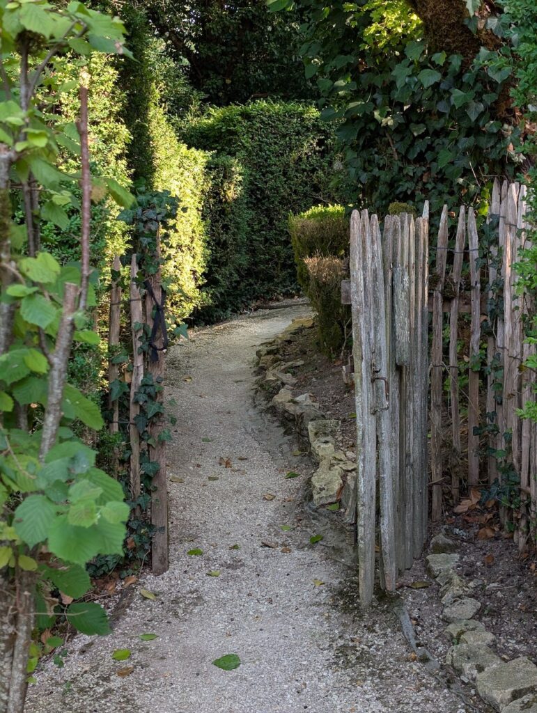 Rustic wooden gate opening onto a dirt pathway
