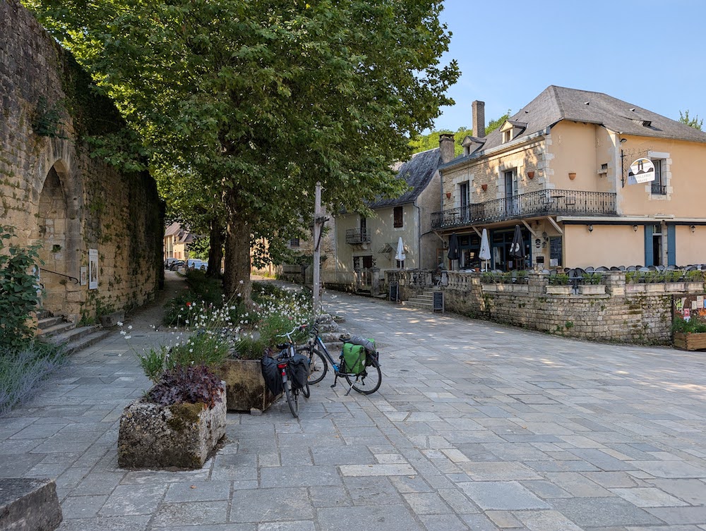 Village in the South of France featuring quaint stone buildings, bicycles, flower boxes, and a flagstone street 