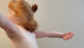 A young girl dancing; her movement is blurred