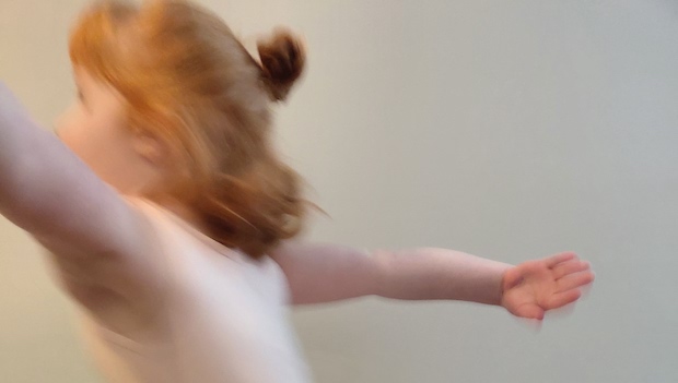 A young girl dancing; her movement is blurred