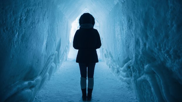 Person in an ice cave or tunnel with their back to the camera