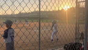 Children playing baseball at sunset