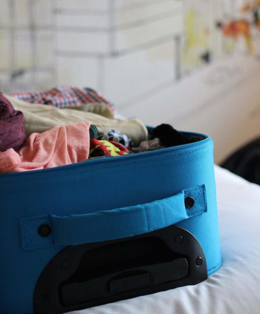 Open blue suitcase containing clothes