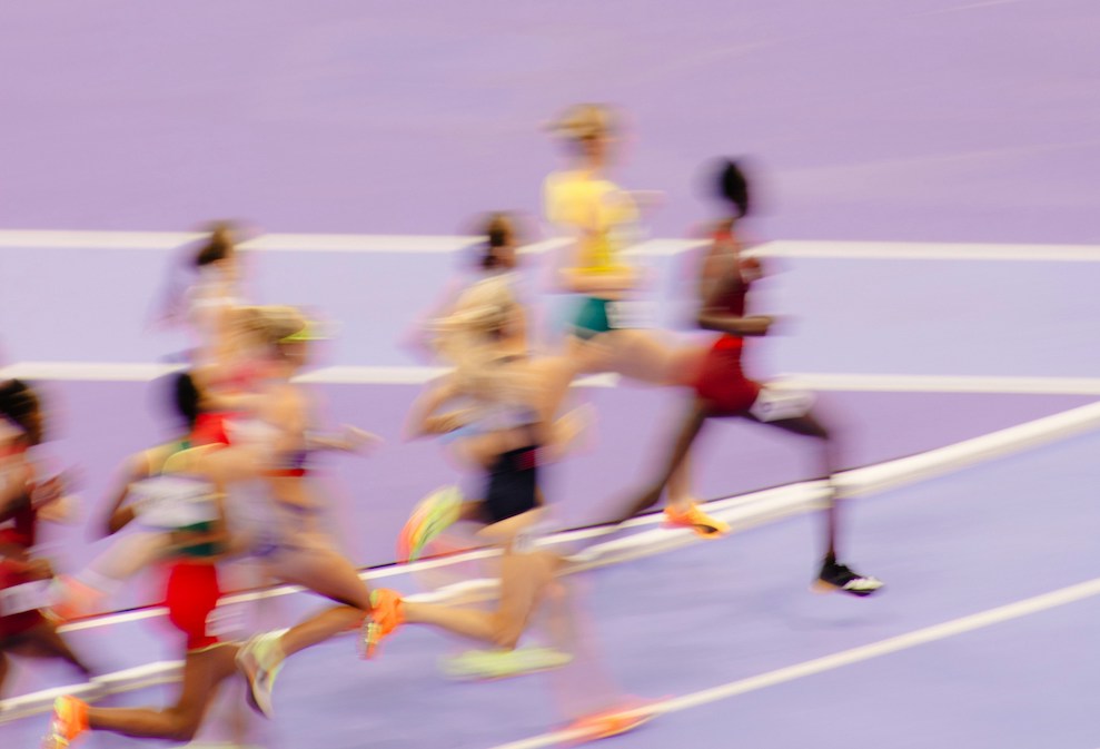 Blurry runners on a light purple track