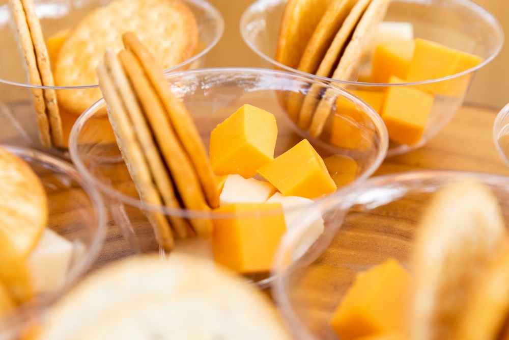 Plastic cups containing round crackers and cheese cubes
