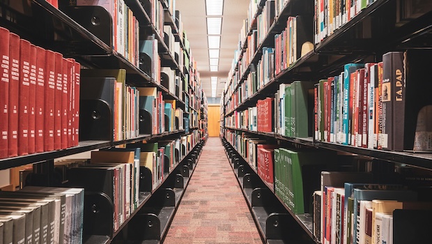 Library shelves, seen from the center of a long aisle