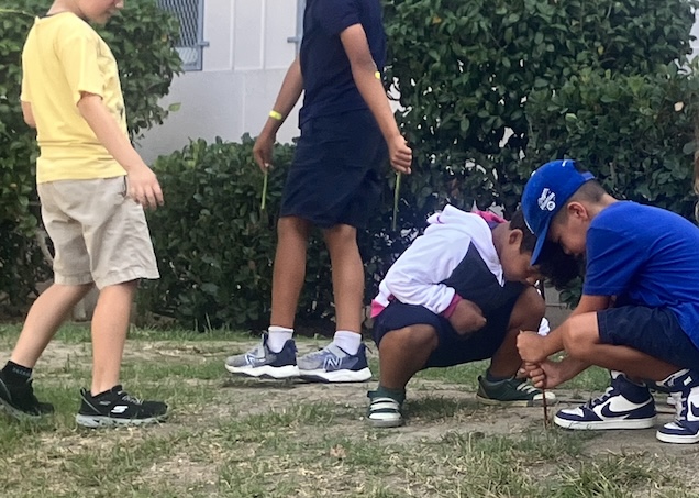 Young boys playing in front of a school